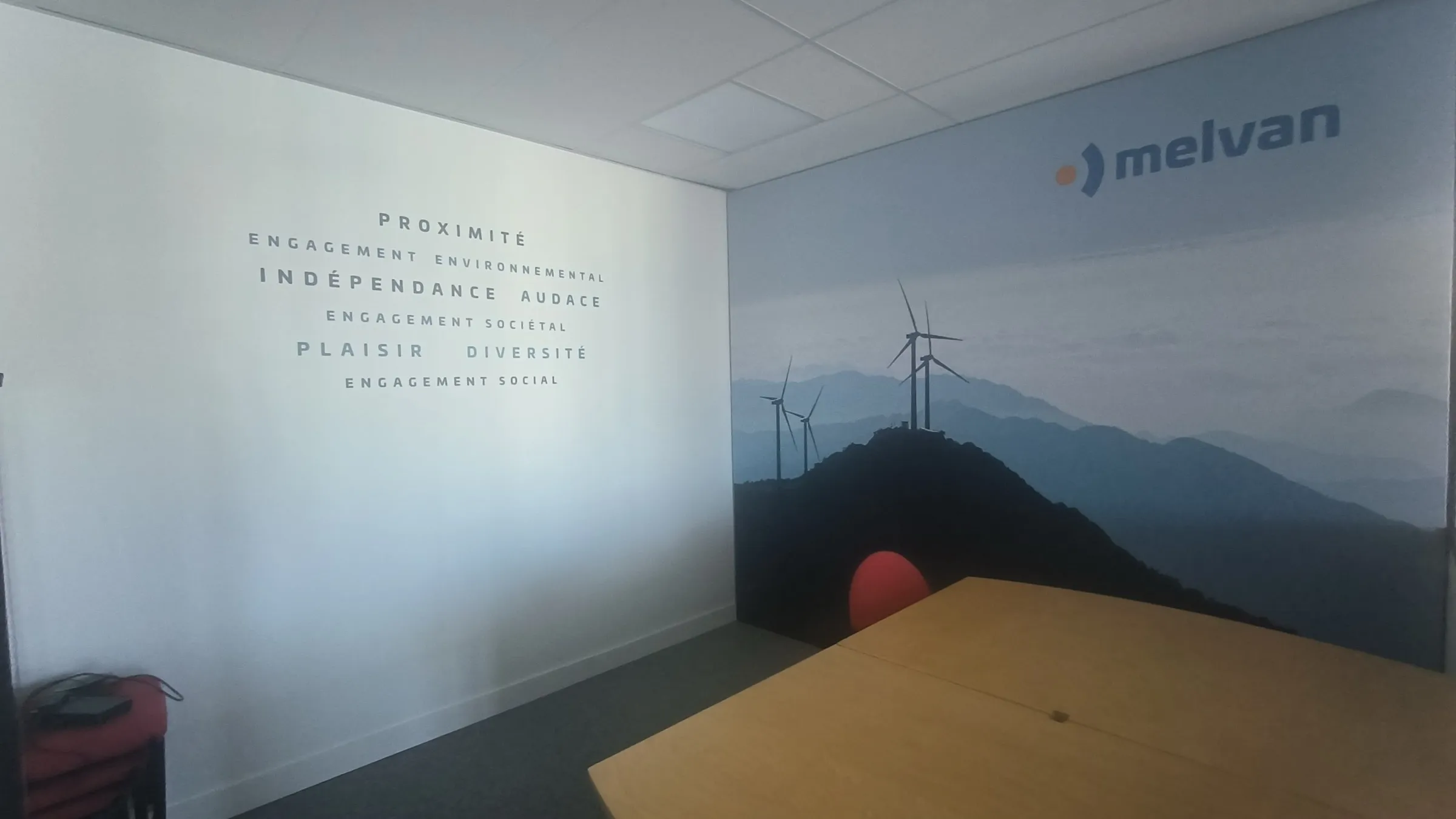 Melvan, Bordeaux — lettrage adhésif et cadre toile jonc cousu sur mur de bureau — réalisation PUBLI MENI
