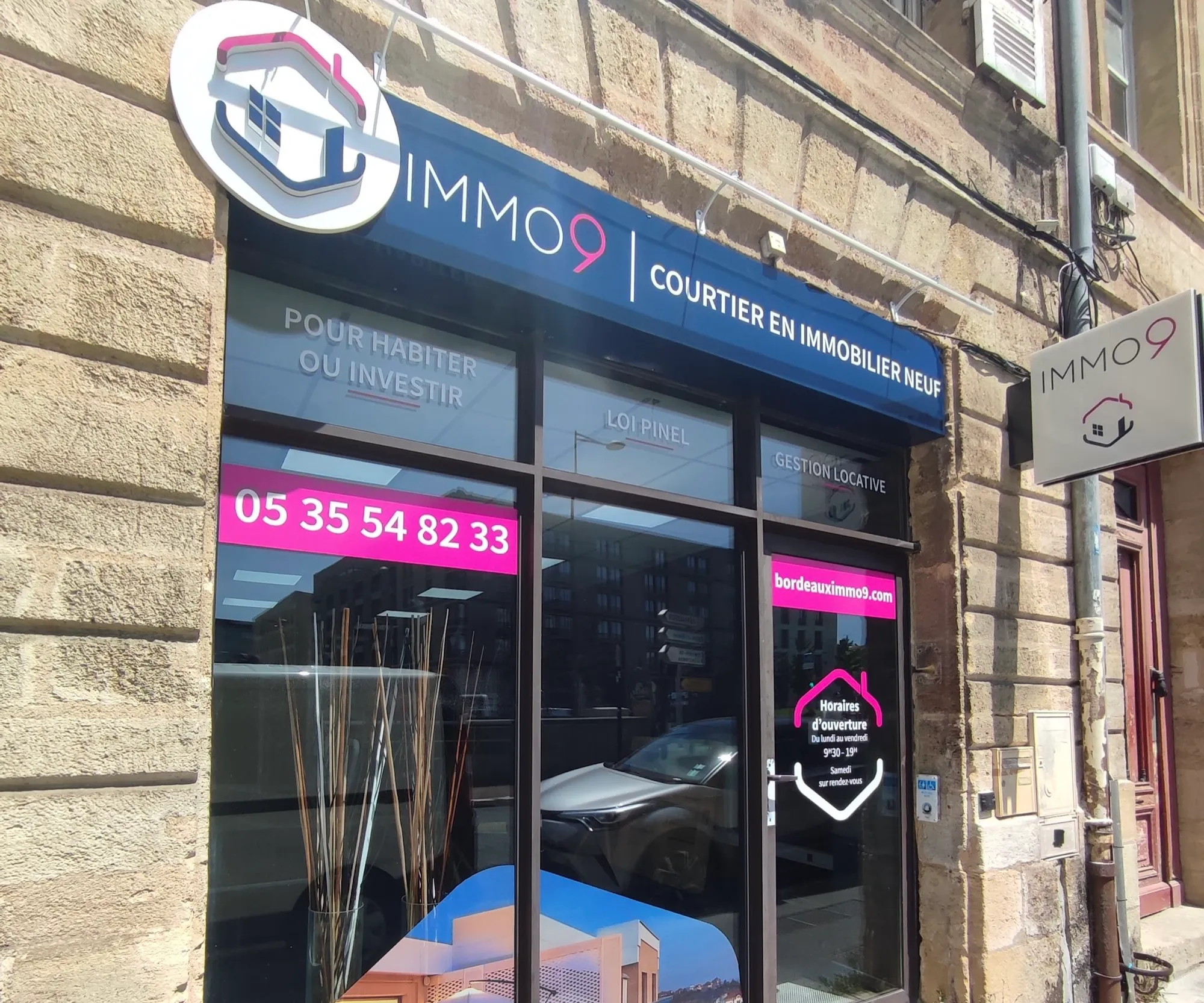 IMMO9, Bordeaux — vitrine habillée d'adhésif imprimé avec enseigne drapeau — réalisation PUBLI MENI