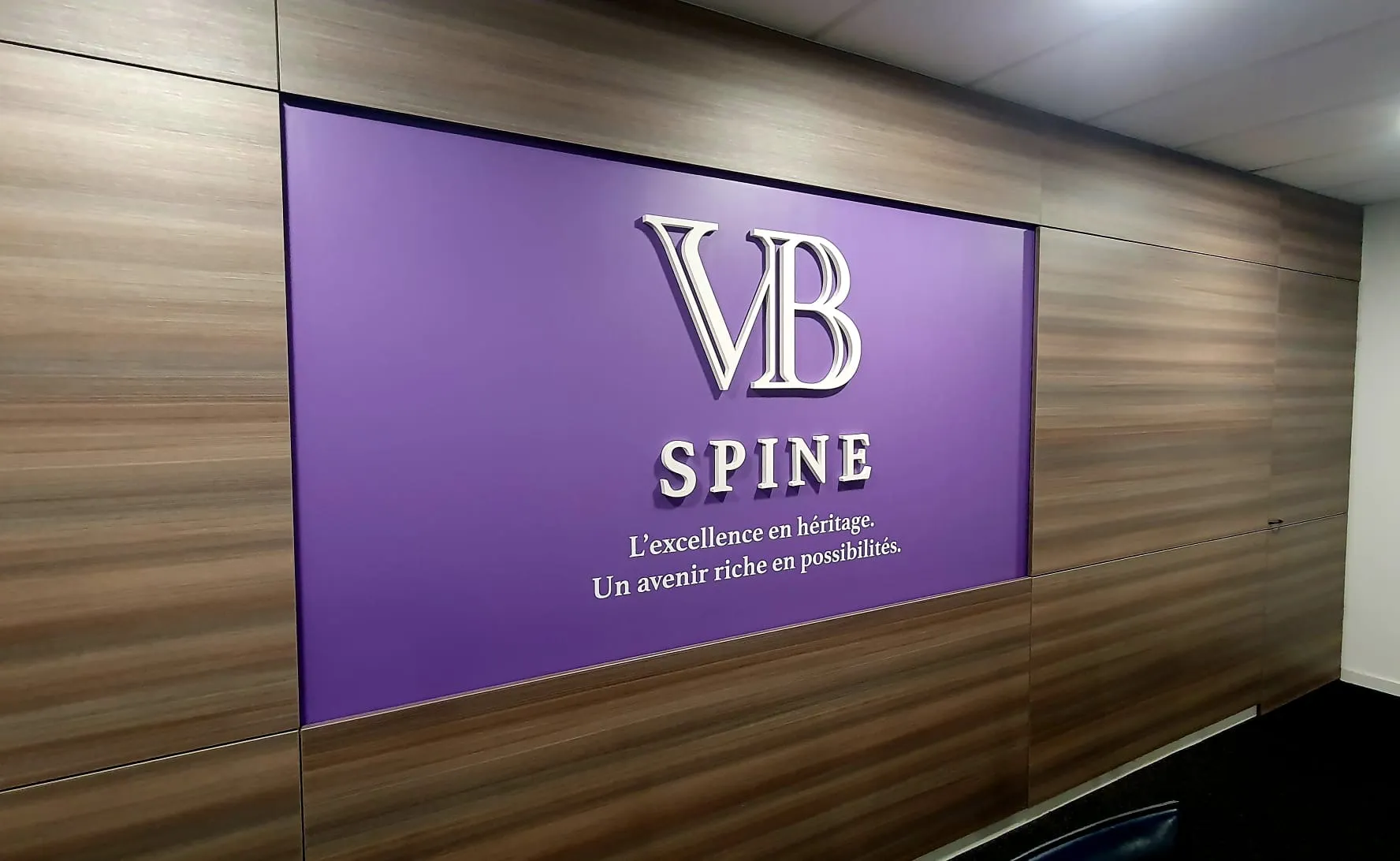 VB Spine, Cestas — panneau logo en relief sur habillage mural bois en salle de réunion — réalisation PUBLI MENI
