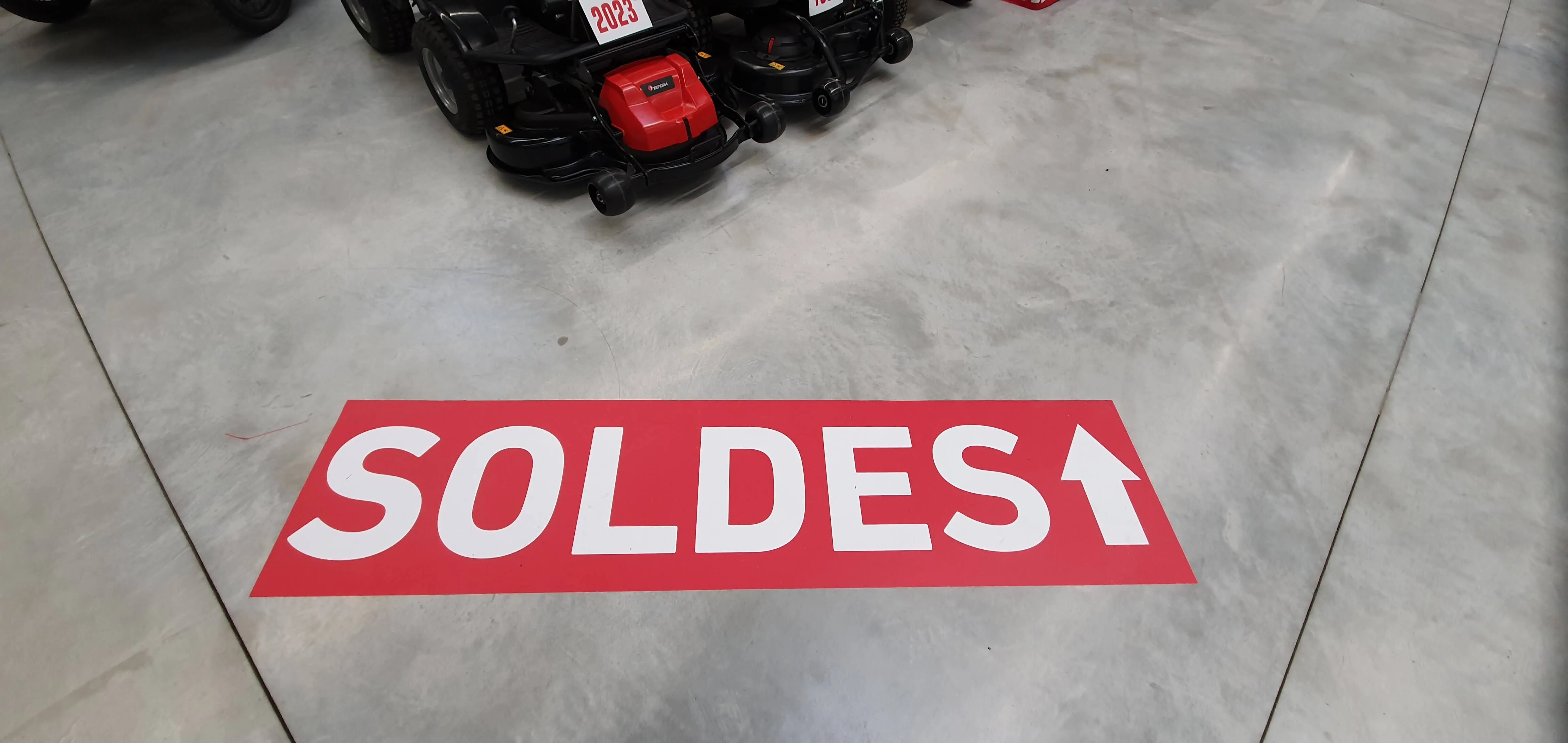 Sticker sol "Soldes" avec flèche directionnelle, en magasin — réalisation PUBLI MENI
