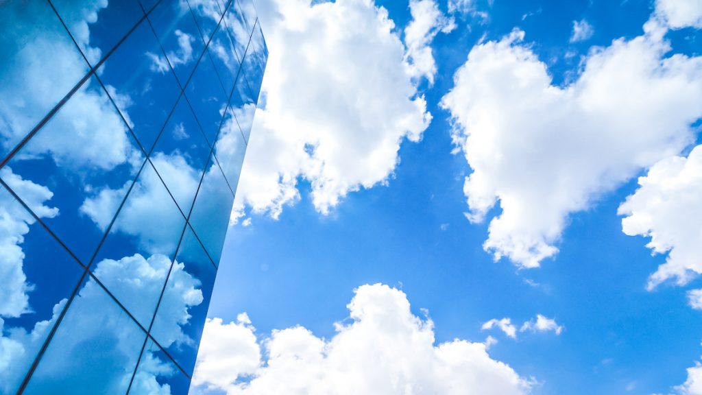 Building vitré et ciel bleu avec quelques nuages